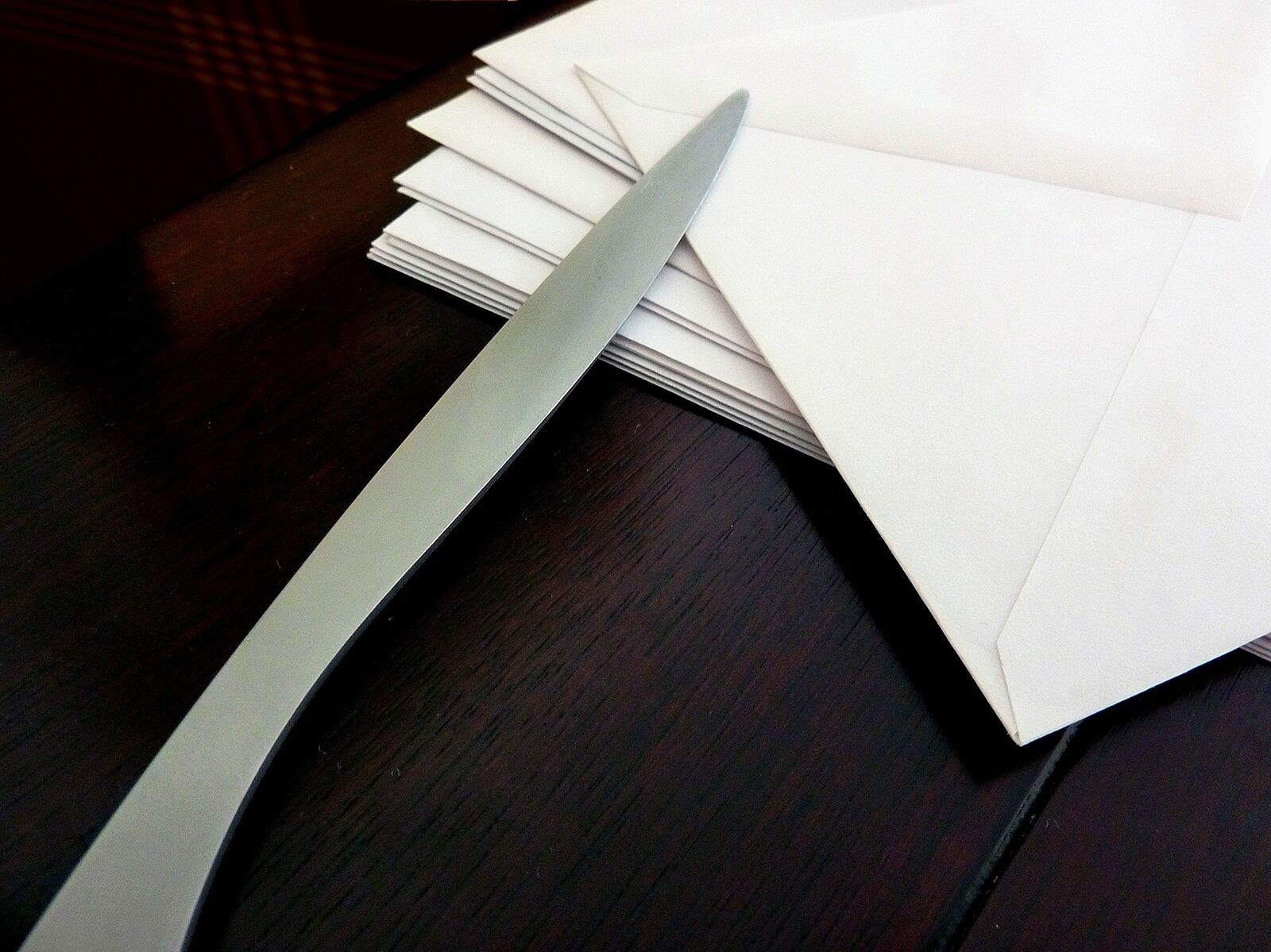 Ein Stapel weißer Briefumschläge und ein Brieföffner