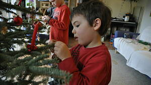 Kind schmückt Weihnachtsbaum