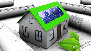Hausmodell mit einem grünen Dach und Solarpanels darauf