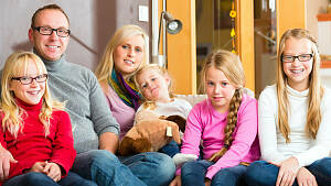 Eltern mit 4 Kindern auf dem Sofa