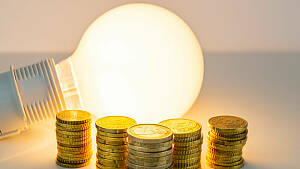 Symbolbild - Glühlampe und Geld