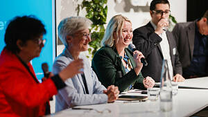 Ein langes Pult mit 4 Teilnehmenden an einer Pressekonferenz