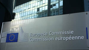 Schriftzug und Logo der EU-Kommission auf einem metallenen Schild vor einem Gebäude