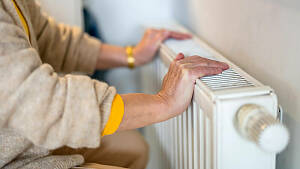 Zwei Hände liegen auf einem Heizkörper