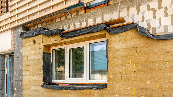 Themenbild: Ansicht eines Hauses, dass gedämmt wird
