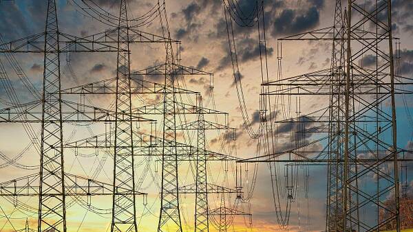 Themenbild: Netz aus Stromleitungen vor Himel mit dunklen Wolken