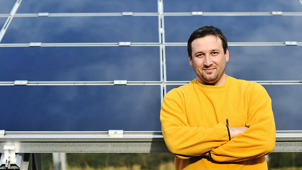 Themenbild: Mensch vor Solaranlage