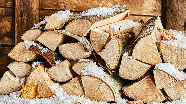 Themenbild: ein Stapel Kaminholz mit etwas Schnee darauf Themenbild: ein Stapel Kaminholz mit etwas Schnee darauf