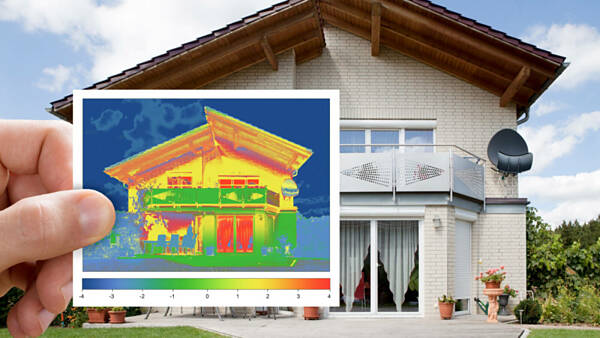 Themenbild: Jemand hält ein Bild von einem Haus, welches mit einer Wärmebildkamera gemacht wurde, vor das Gebäude. Themenbild: Jemand hält ein Bild von einem Haus, welches mit einer Wärmebildkamera gemacht wurde, vor das Gebäude.