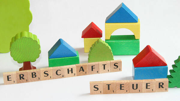 Themenbild: Kleine Landschaft mit Häusern und Buchstaben, auf denen Erbschaftssteuer steht