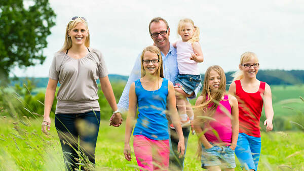 Themenbild: Familie läuft auf Wiese