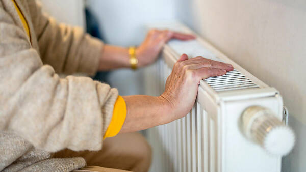 Themenbild: Zwei Hände liegen auf einem Heizkörper