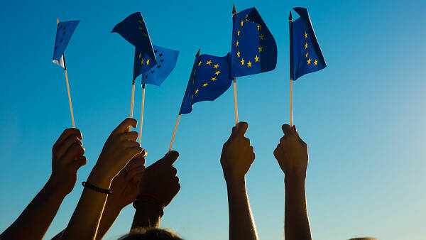 Themenbild: Hände halten Europafahnen in die Luft