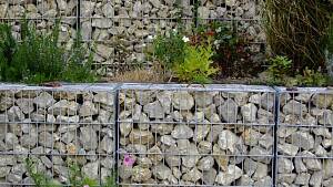 Gabionenmauer zur Hangabstützung, mit gebrochenen Steinen gefüllt