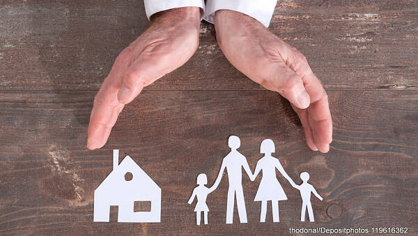 Themenbild: Beschützende Hand über Haus und Familie