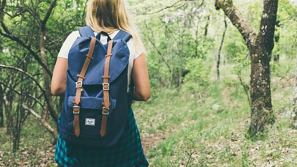 Themenbild: Wanderin mit Rucksack auf Weg Themenbild: Wanderin mit Rucksack auf Weg