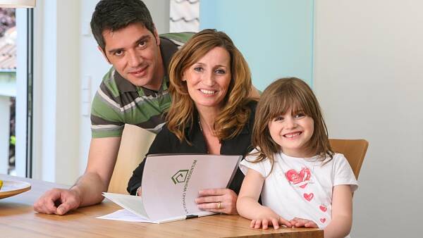 Themenbild: Familie am Tisch mit Mitgliederunterlagen