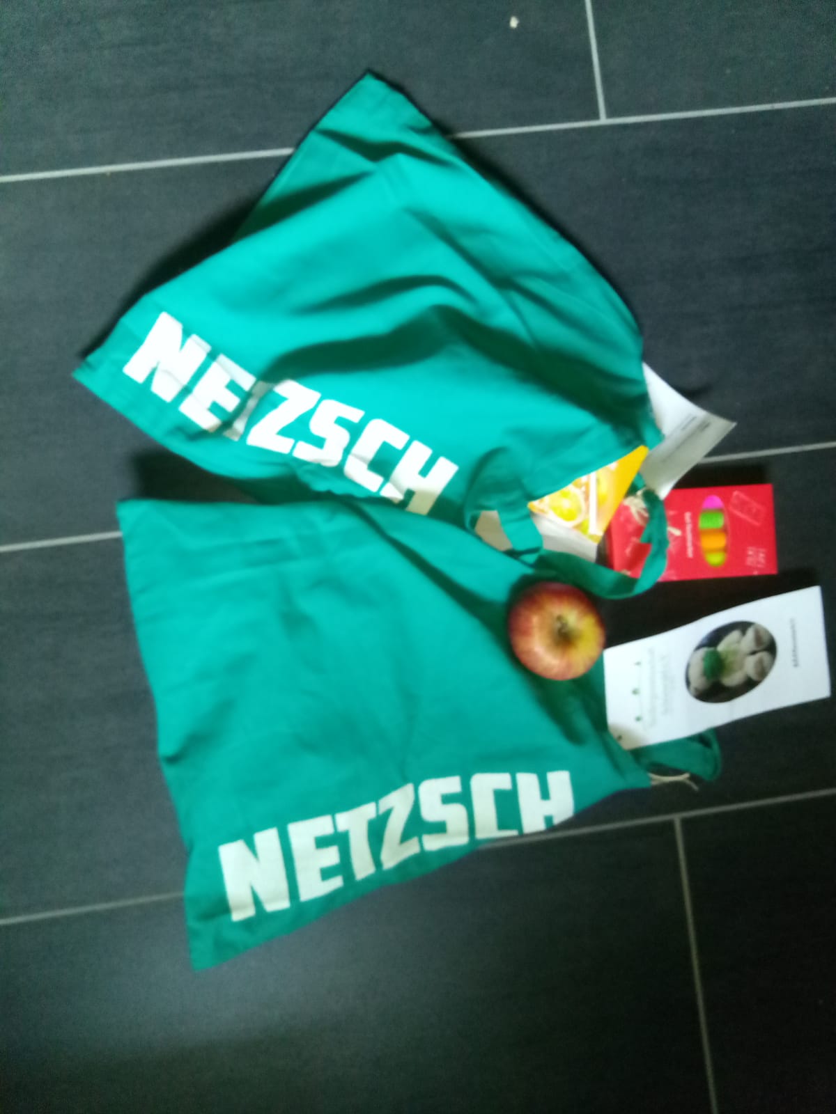 grüne Tasche mit Ball, Textmarker und Apfel usw.