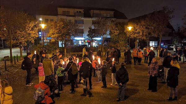 Themenbild: Menschen sammeln sich vor der Fackelwanderung auf dem Marktplatz Rheinau-Süd