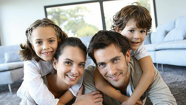 Themenbild: Themenbild: Familie auf Teppich glücklich beisammen